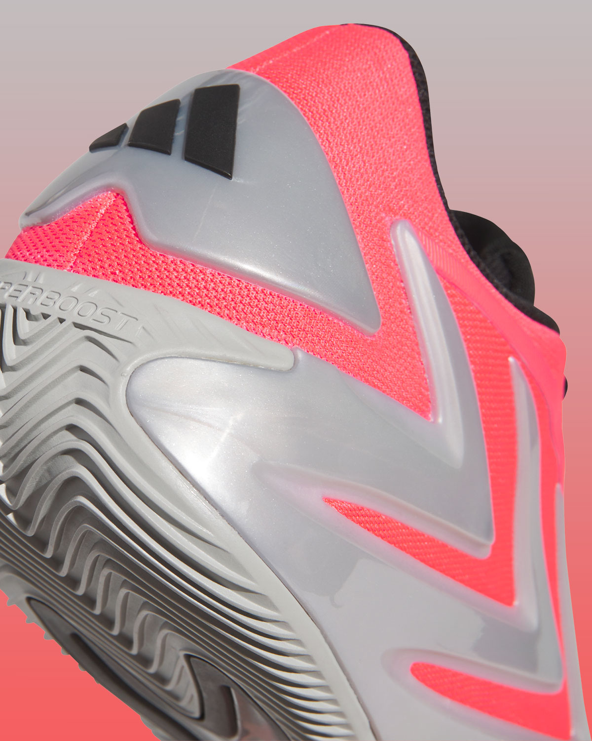 Primer plano del talón del adidas AE 3 Omen, con el clip plateado y las tres barras negras de adidas, la malla roja y la inscripción Hyperboost en la mediasuela gris