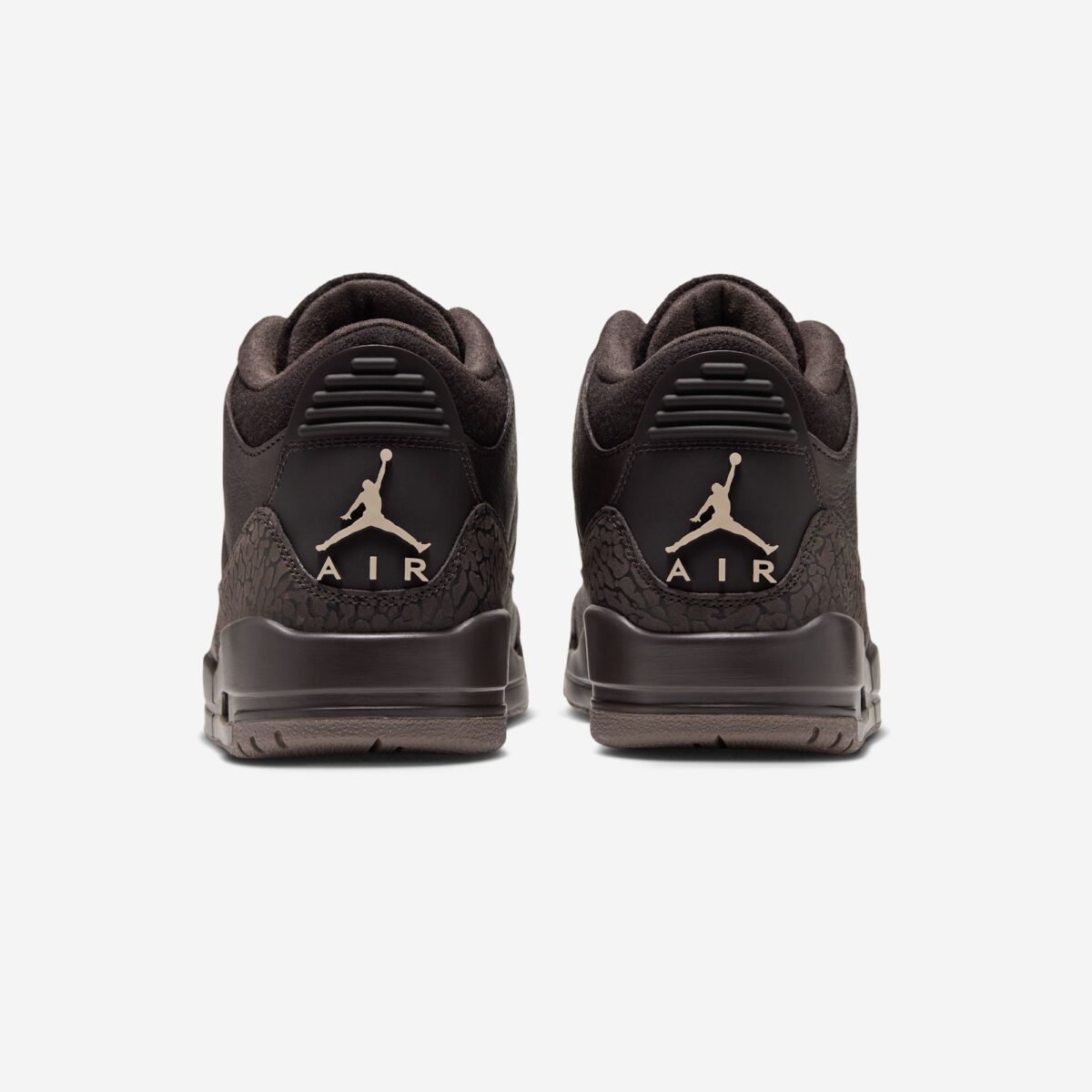 Vista trasera de un par de Air Jordan 3 Fireside marrones, con el Jumpman y la palabra AIR en beige en cada talón, elephant print marrón alrededor y suela marrón