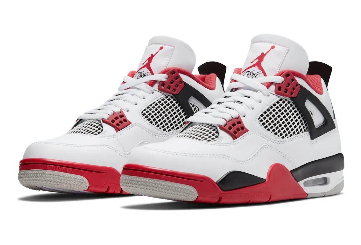 Foto de archivo: par del Air Jordan 4 Fire Red de 2020 en diagonal sobre fondo blanco, con upper de cuero blanco, ojales rojos, alas negras, malla blanca y negra, Jumpman rojo con la palabra Flight en la lengüeta, forro rojo y mediasuela roja y negra con suela gris