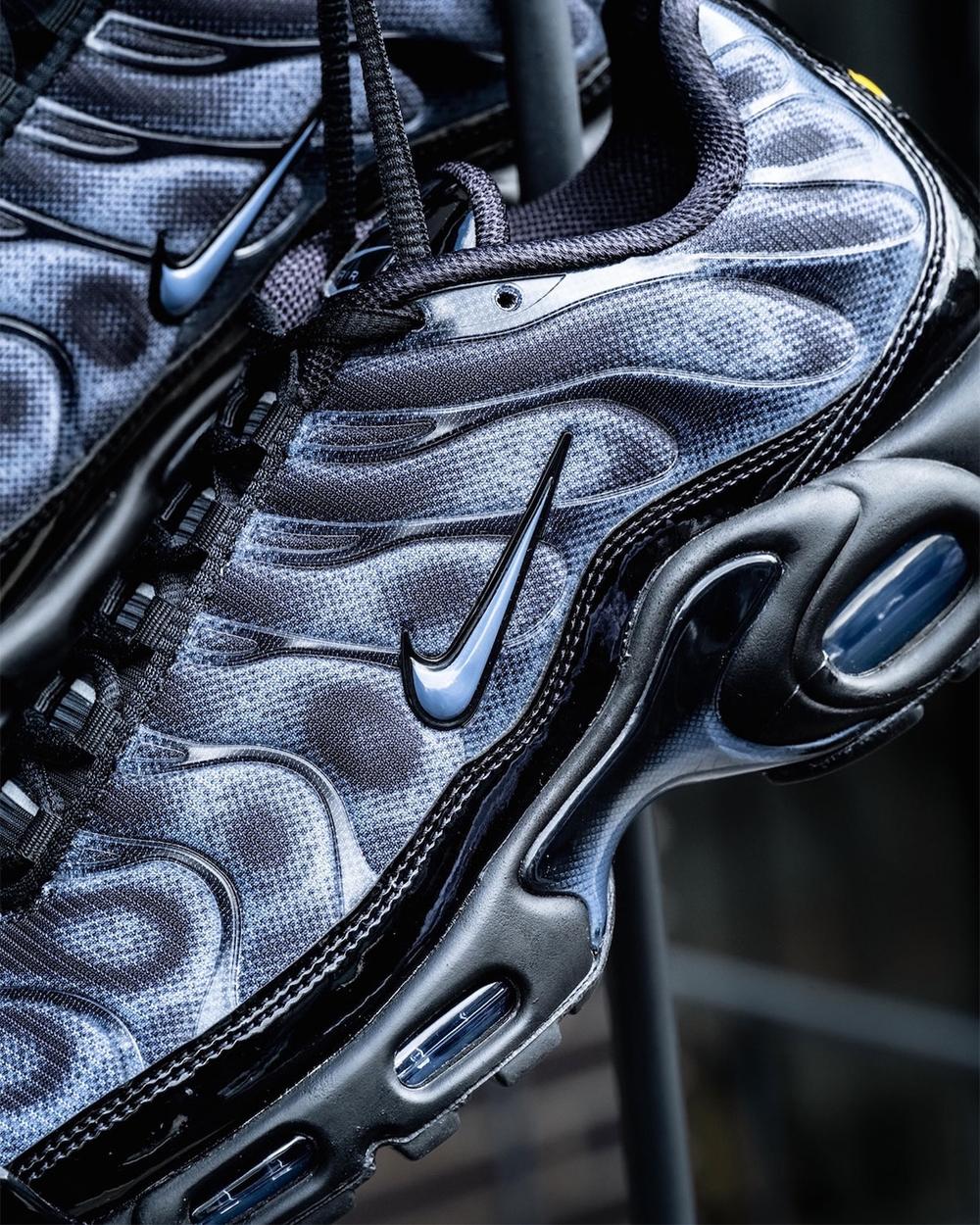 Detalle del costado del Nike Air Max Plus negro y gris con el patrón de puntos sobre la malla, las ondas laterales con el mismo efecto, el Swoosh y la burbuja de aire