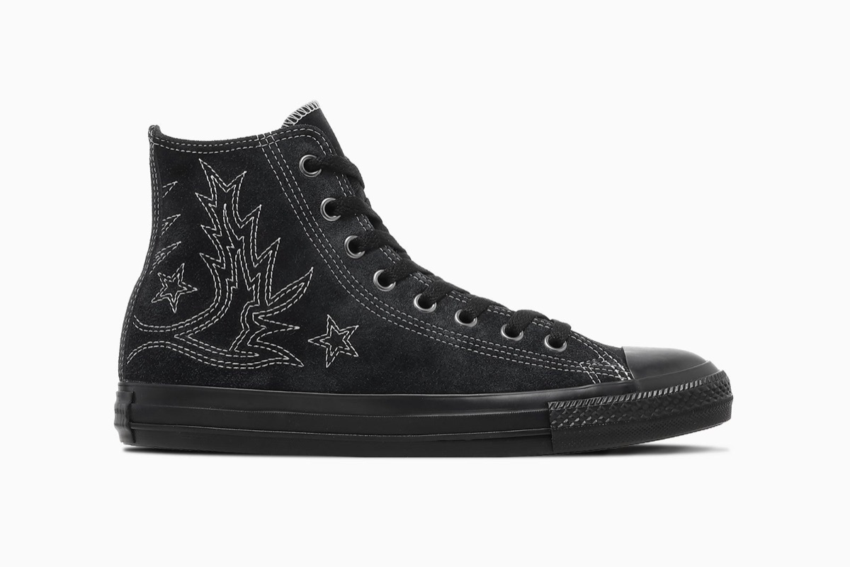 Converse All Star Westernstitch SU HI en negro de perfil sobre fondo blanco, con capellada de gamuza negra, pespuntes blancos con dibujo de bota vaquera y dos estrellas en el costado, ojalillos plateados, cordones negros y suela de goma negra