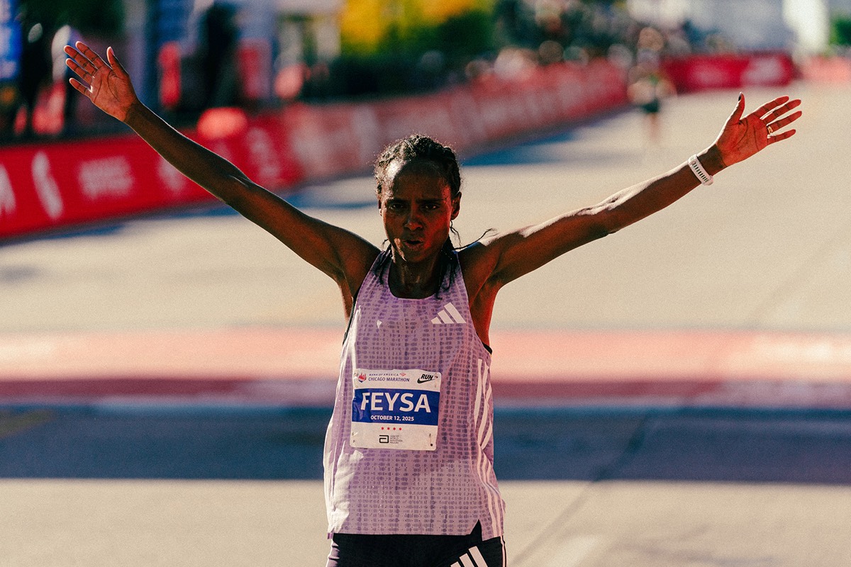 Foto de archivo: Hawi Feysa, con musculosa lila y el dorsal con su apellido, abre los brazos al llegar a la meta del Maratón de Chicago 2025