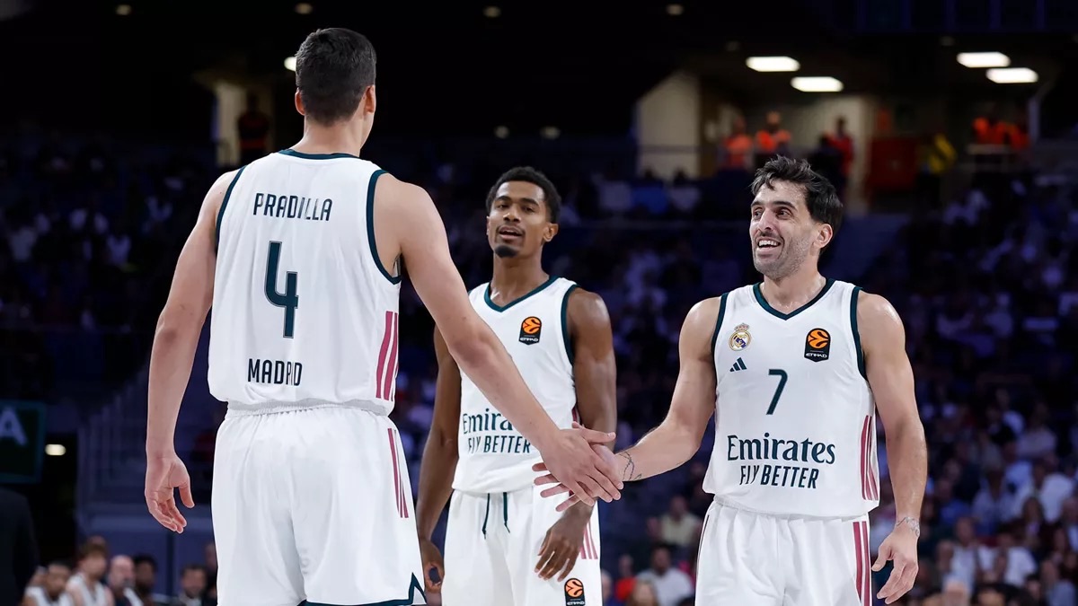Facundo Campazzo, con la camiseta blanca número 7 del Real Madrid, sonríe y choca la mano de Jaime Pradilla durante el partido ante el Partizan en el Movistar Arena