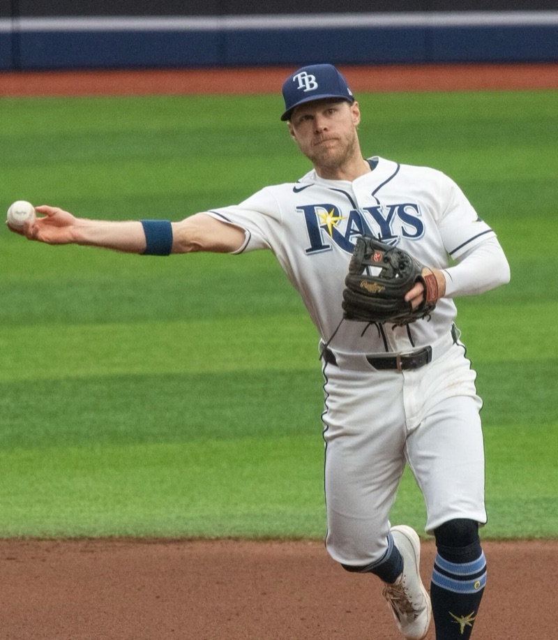 Foto de archivo: Taylor Walls, con la camiseta blanca de los Rays, tira la pelota a primera base después de atajar un roletazo en el campo de juego