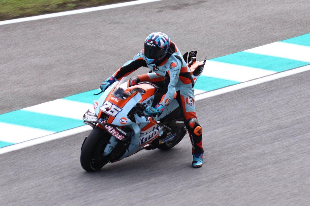 Foto de archivo: Raúl Fernández, con buzo celeste y naranja, inclina la Aprilia número 25 del equipo Trackhouse en una curva con pianos celestes y blancos