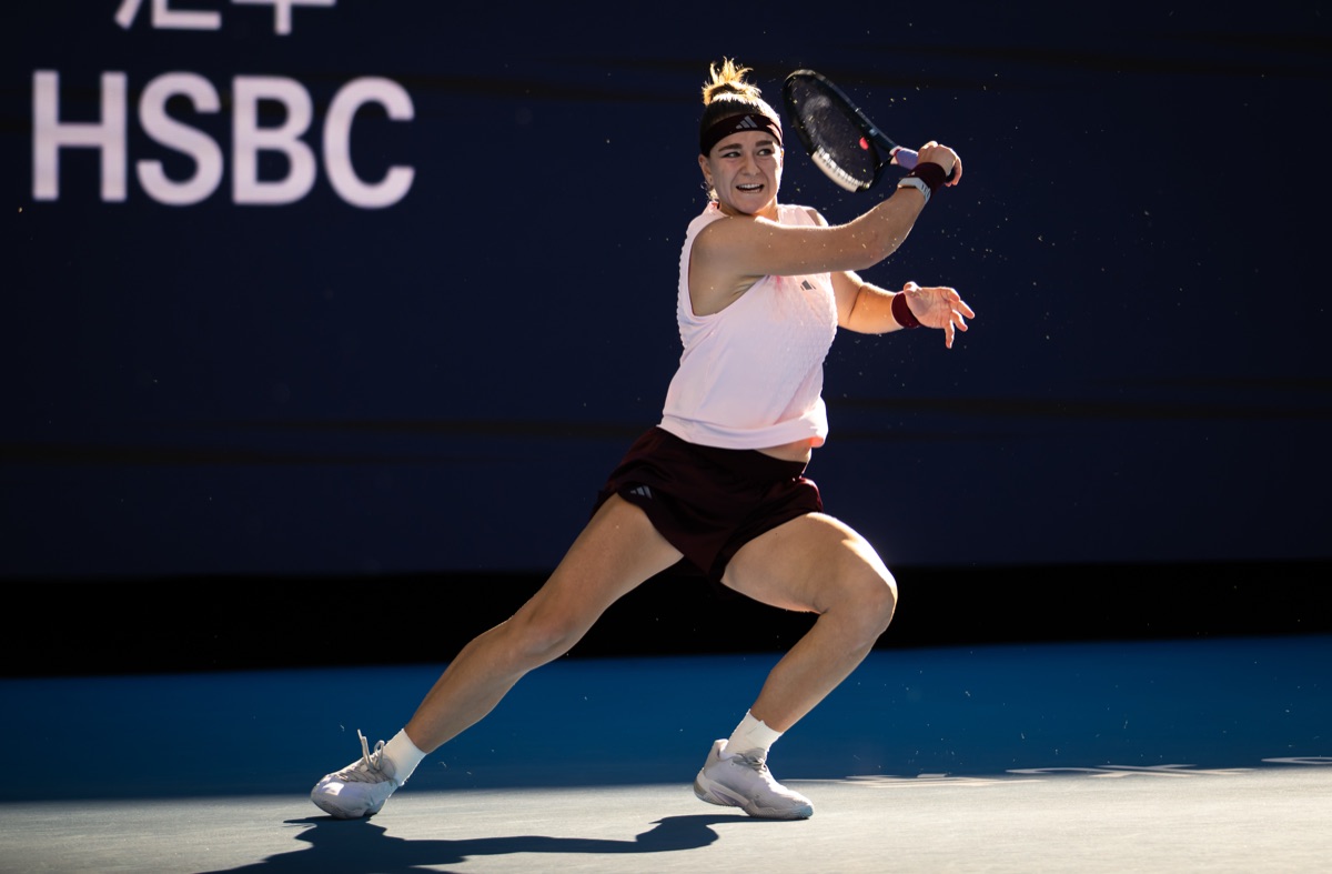 Karolina Muchova, con musculosa rosa clara, short bordó y vincha, pega un drive en su partido de octavos de final del China Open 2026 ante Naomi Osaka