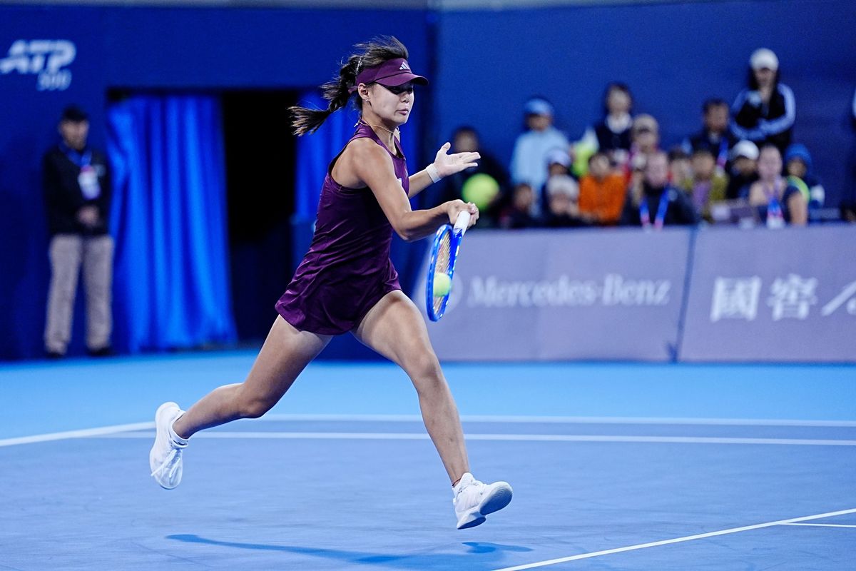 Sun Xinran, con visera y vestido bordó, corre para pegar una derecha en una cancha azul del China Open 2026