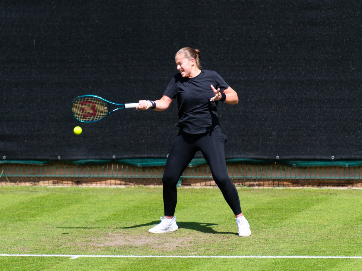 Foto de archivo: Jelena Ostapenko, de negro, pega un drive en una cancha de césped durante un entrenamiento en Birmingham 2024