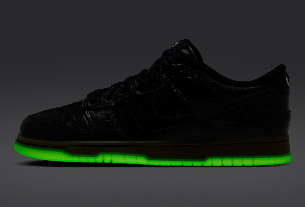 Nike Dunk Low Shibuya Halloween de perfil en la oscuridad, con la suela encendida en verde fluorescente y el upper negro casi invisible