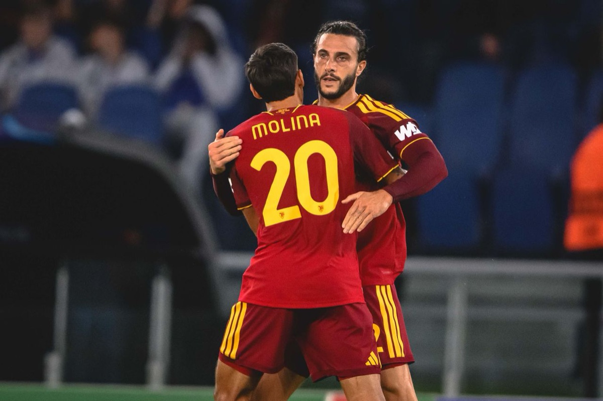 Nahuel Molina, de espaldas con la camiseta bordó de la Roma, el número 20 y su apellido, se abraza con un compañero para festejar en el estadio Olímpico (foto: AS Roma)