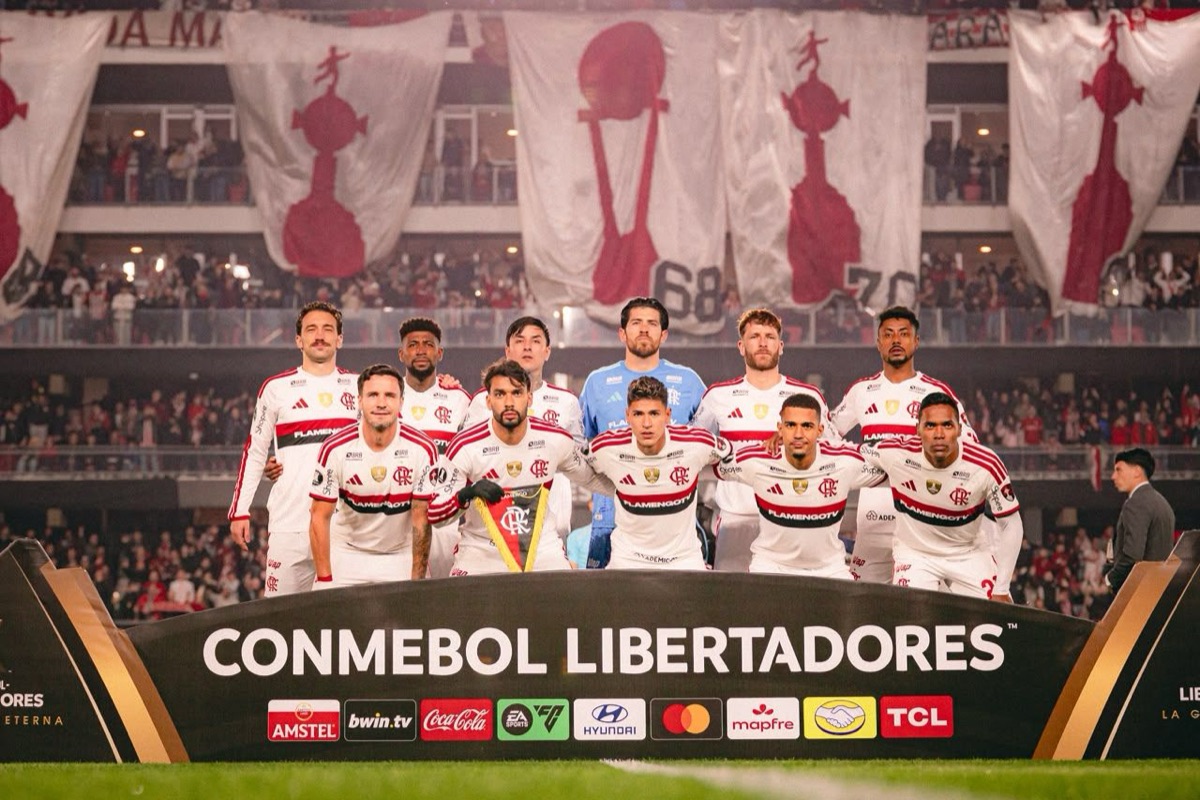El equipo titular de Flamengo, con su camiseta blanca, posa detrás del cartel de la CONMEBOL Libertadores antes de la ida en el estadio UNO de La Plata; foto de archivo del jueves 15 de octubre (foto: Adriano Fontes / prensa oficial de Flamengo, CRF)