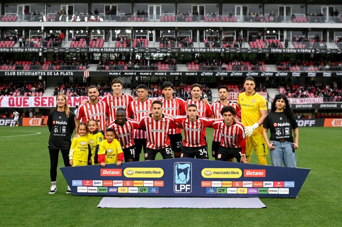 Los titulares de Estudiantes posan para la foto antes del partido ante San Lorenzo, junto a chicos con la camiseta del club, frente a la tribuna del estadio UNO (foto: prensa oficial de Estudiantes de La Plata)
