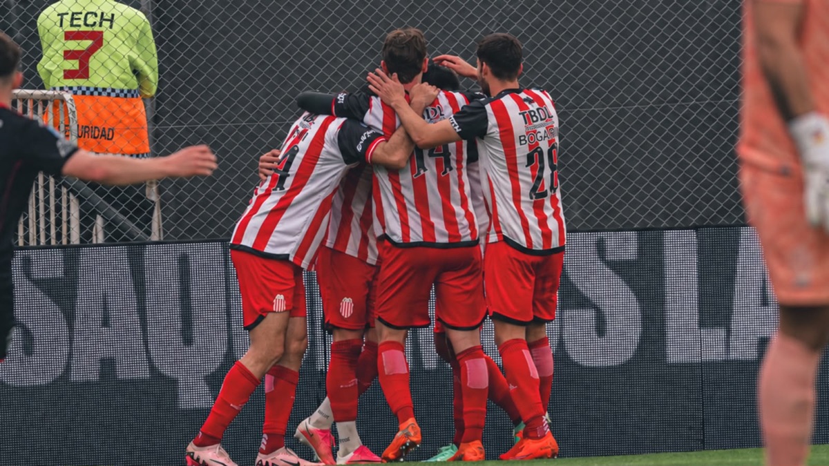 Los jugadores de Barracas Central, con la camiseta a rayas rojas y blancas, se abrazan en el festejo de un gol ante Huracán en el estadio Claudio Chiqui Tapia (foto: prensa Barracas Central)