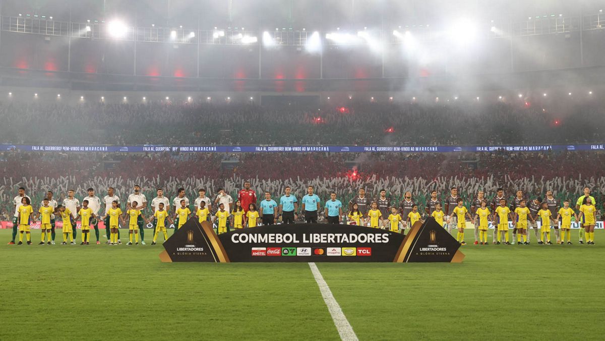 Los planteles de Palmeiras y Fluminense, formados junto al equipo arbitral detrás del cartel de la CONMEBOL Libertadores, con las tribunas del Maracaná llenas antes del partido (foto: Cesar Greco / Palmeiras)