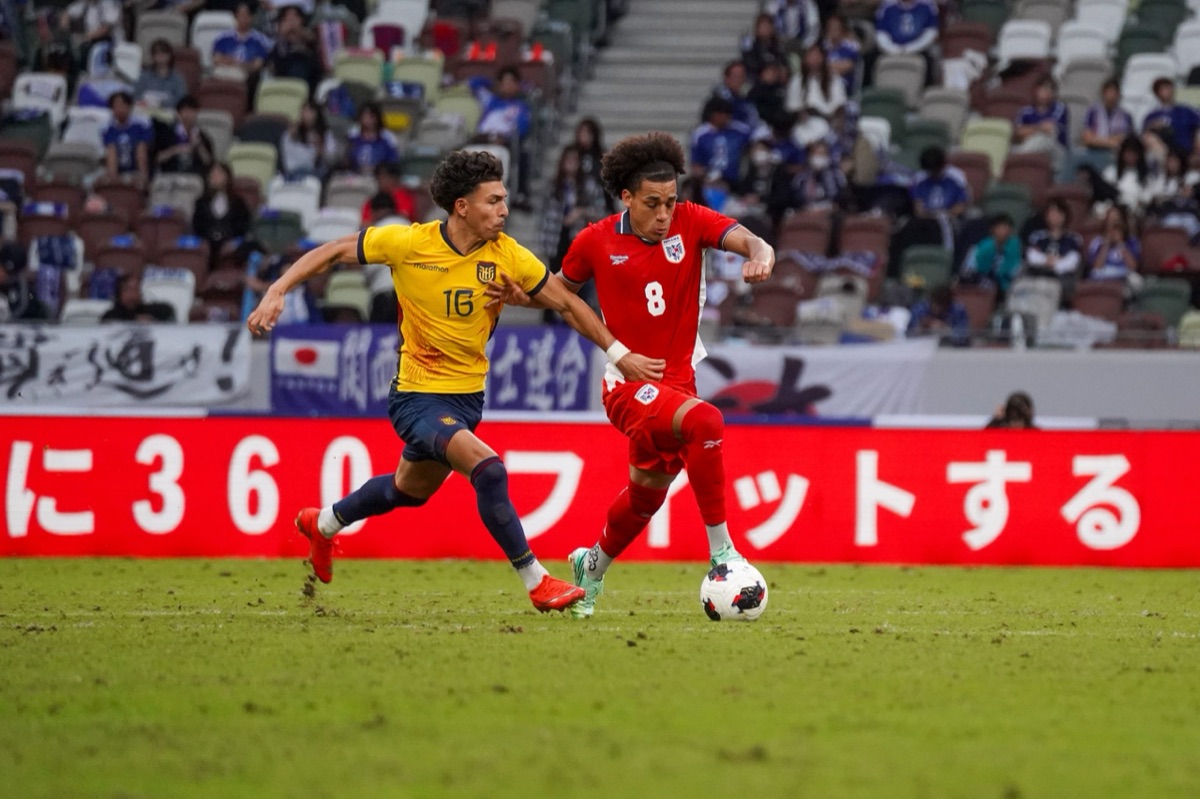 Jeremy Sarmiento, de Ecuador, con la camiseta 16, persigue a Adalberto Carrasquilla, de Panamá, en el Estadio Nacional de Tokio (foto: Federación Panameña de Fútbol)