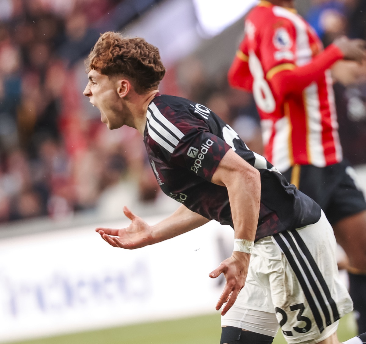 Víctor Muñoz, con la camiseta oscura número 23 de Liverpool, grita el gol del empate ante Brentford, con un jugador local de rojo y blanco de fondo (foto: prensa Liverpool FC)