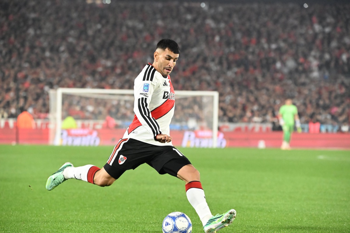 Un jugador de River, con la camiseta de manga larga, se prepara para patear la pelota en el Monumental ante Estudiantes de Río Cuarto, con el arquero visitante de verde al fondo (foto: prensa River Plate)
