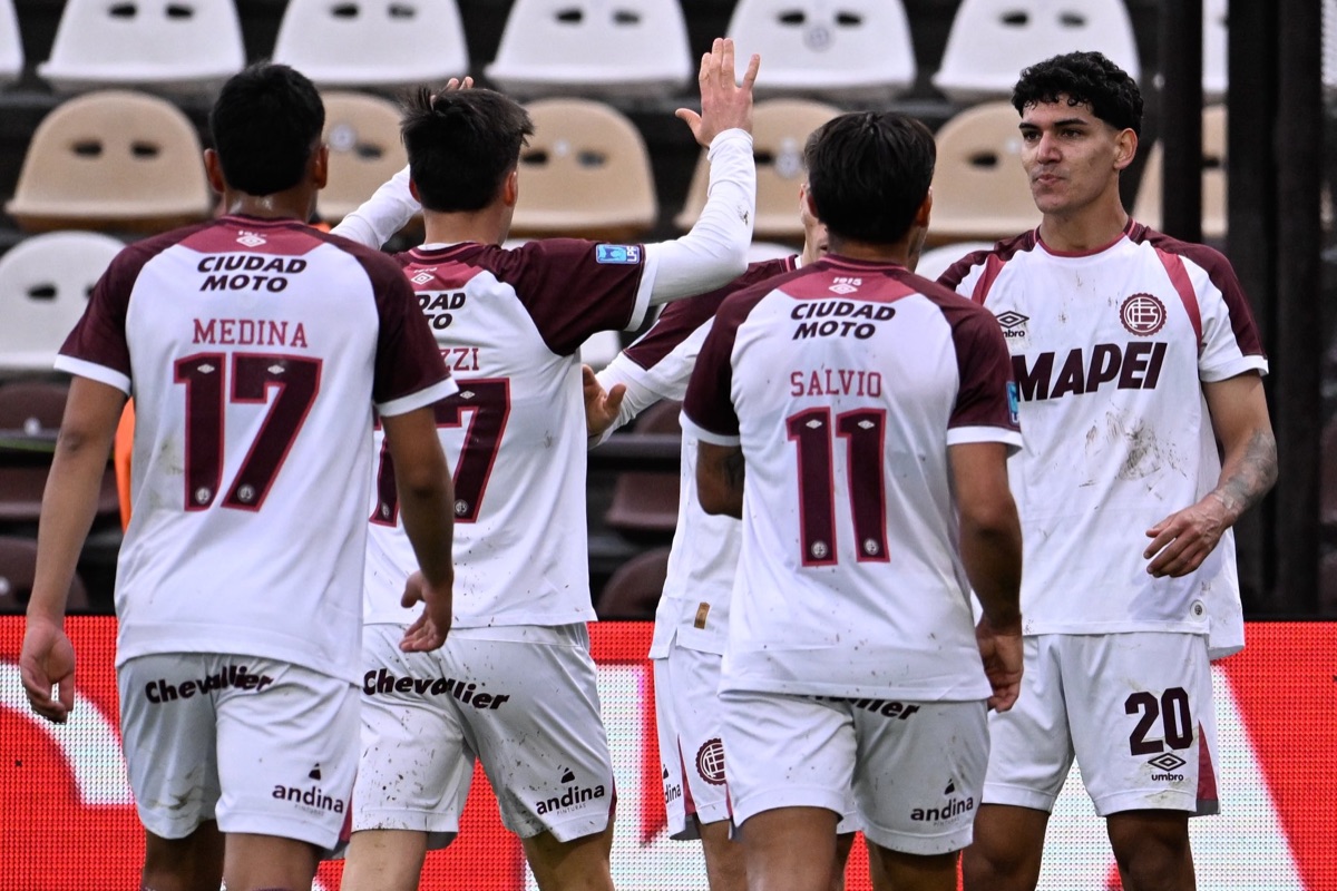 Medina, con el 17, y Salvio, con el 11, de espaldas, festejan con sus compañeros de Lanús, con la camiseta blanca y bordó, el gol ante Platense en el estadio Ciudad de Vicente López (foto: prensa Club Atlético Lanús)