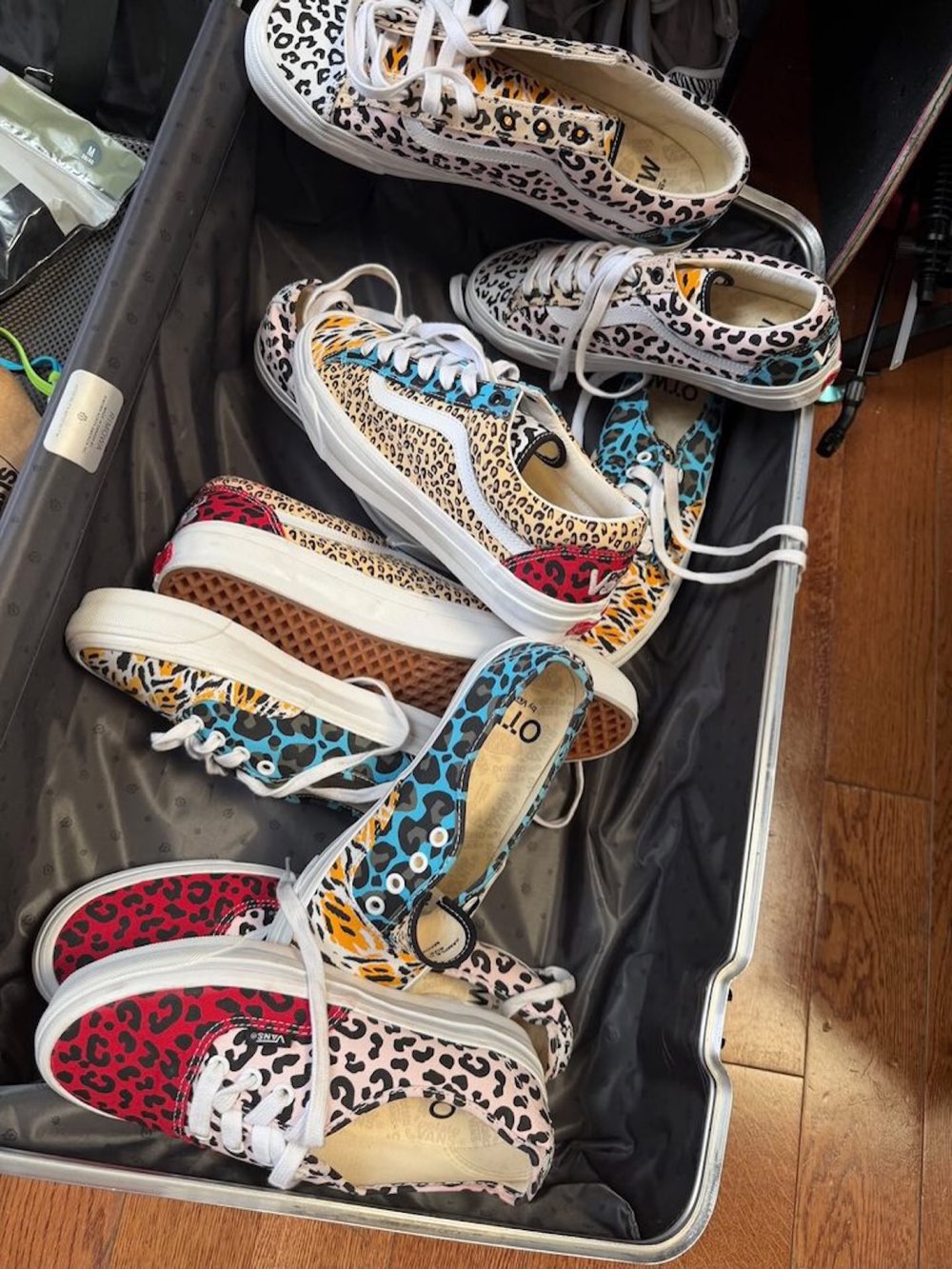 Pares de Imran Potato x Vans Authentic y Old Skool con estampados de leopardo y cheetah en rojo, celeste, amarillo y rosa, acomodados dentro de una valija