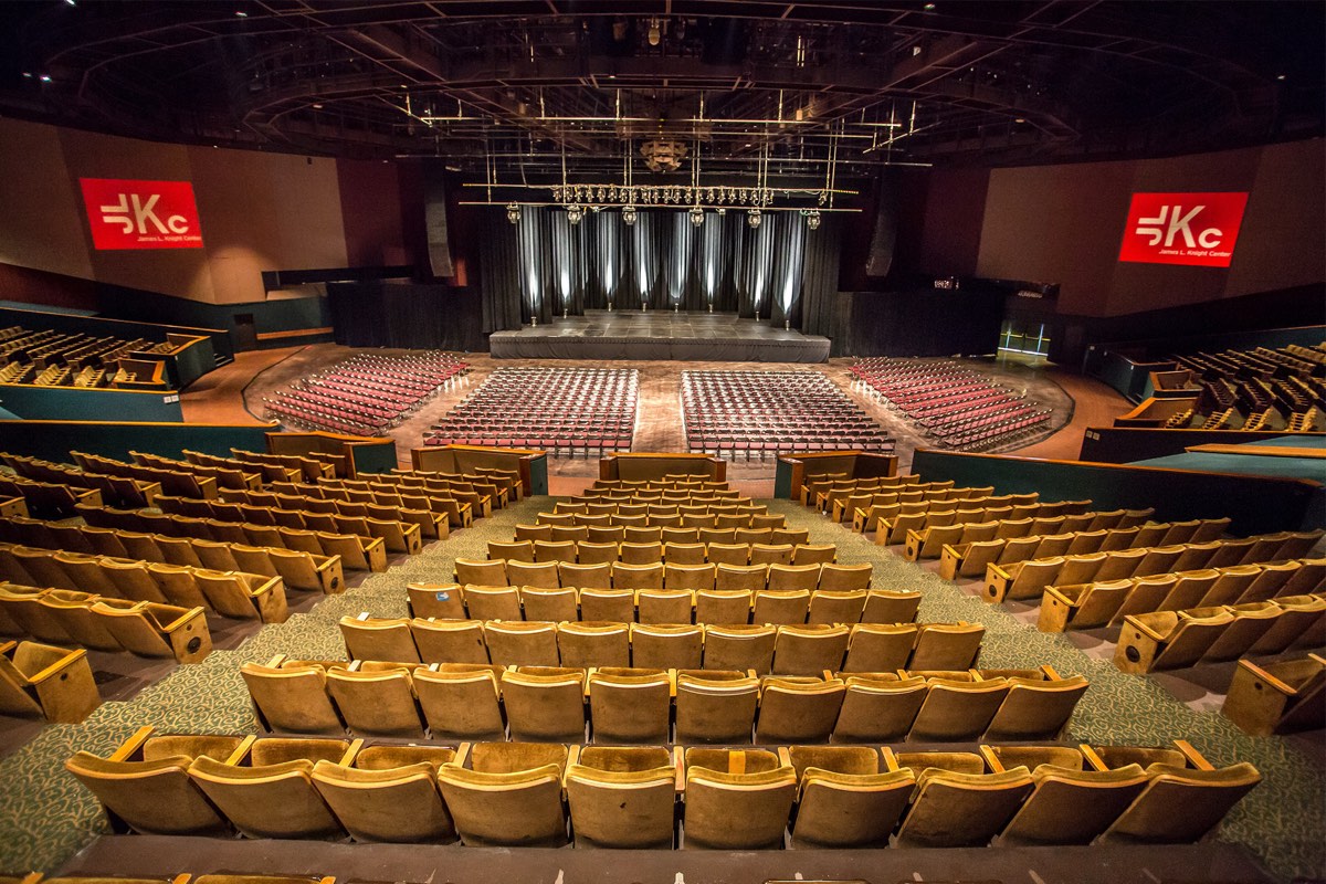 Interior del teatro del James L. Knight Center de Miami, sede de los Premios Billboard de la Música Latina 2026: el escenario al fondo, la platea con sillas rojas y las gradas con butacas doradas. Foto: Gpaz0827 / Wikimedia Commons (CC BY-SA 4.0)