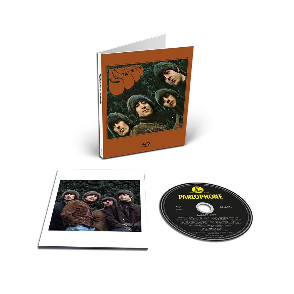 Edición en Blu-ray de Rubber Soul: el estuche con la portada sobre marco marrón, un librito con una foto de los cuatro Beatles parados frente a un cerco verde y el disco con la etiqueta amarilla de Parlophone