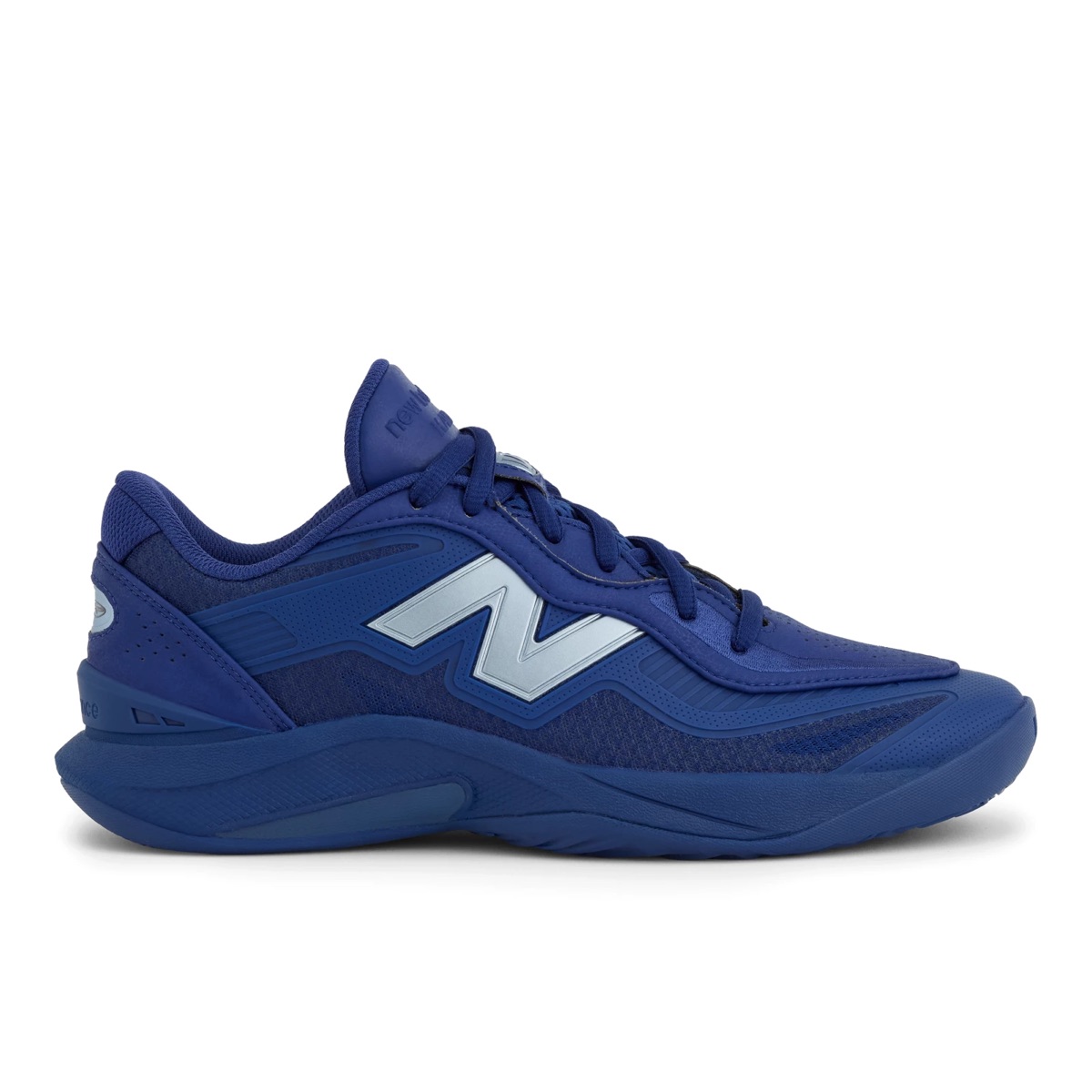 New Balance Kawhi 5 Blue Oyster de perfil lateral sobre fondo blanco, toda en azul profundo, con mesh y paneles al tono, N grande en celeste helado con reflejo plateado, cordones azules y suela azul