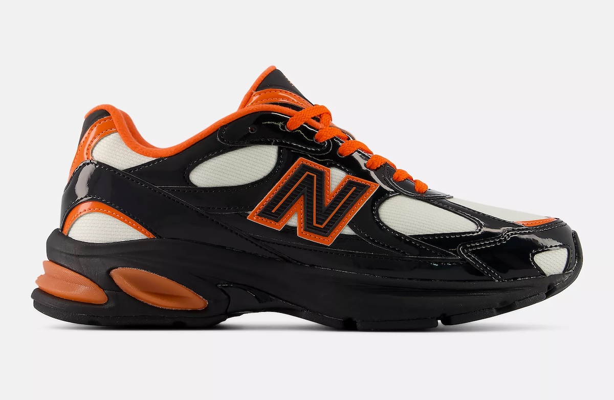Vista lateral externa del New Balance 2010 Halloween sobre fondo gris claro, con capellada de charol negro brillante, paneles de malla crema, logo N negro con borde naranja, cordones y cuello naranjas y pods de amortiguación naranjas en el talón sobre la suela negra