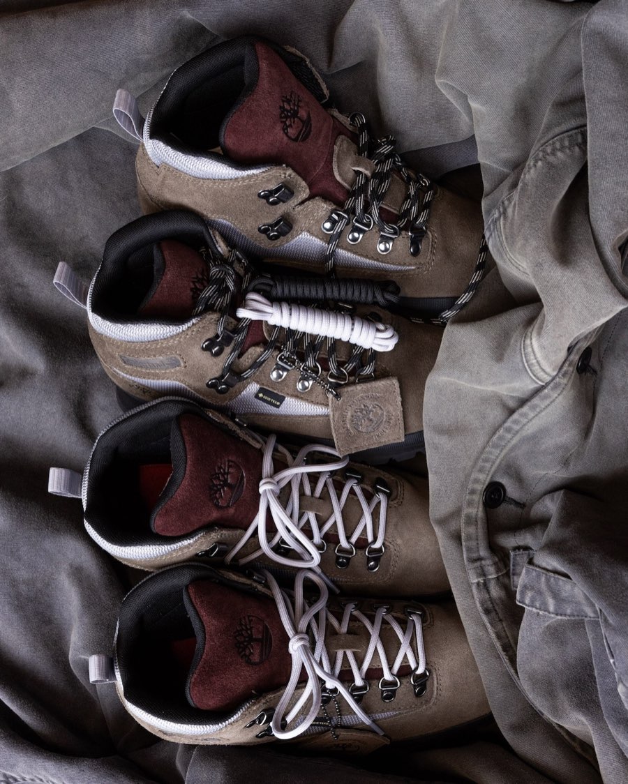 Cuatro botas Victor Kan x Timberland Euro Hiker apoyadas sobre tela gris, en gamuza taupe con lengüeta bordó, malla gris clara y la etiqueta Gore-Tex en el lateral, dos con cordones gris claro y dos con cordones negros con blanco, más un juego de cordones extra enrollado