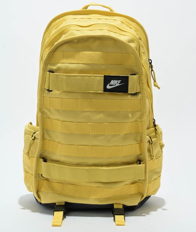 Mochila Nike SB RPM amarilla con cintas cosidas al frente, correas para skate y parche negro con logo Nike